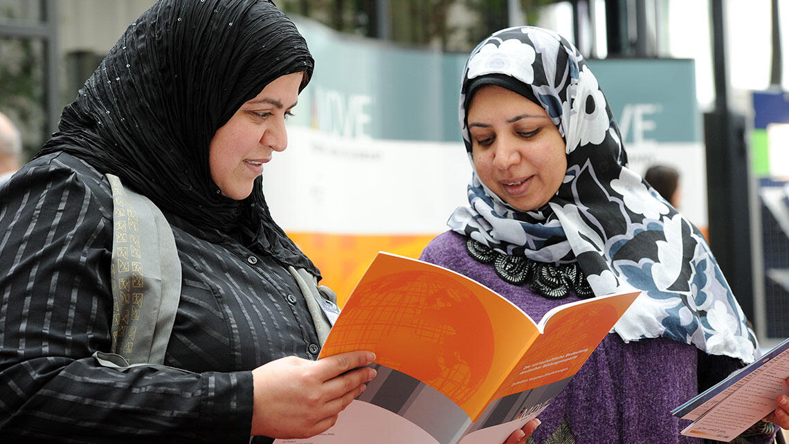 two women leafing through a iMOVE brochure